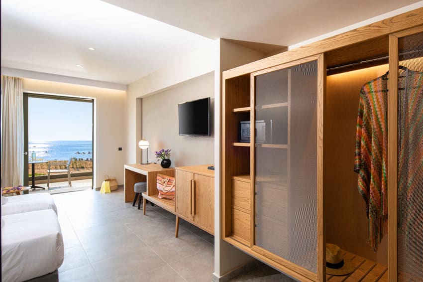 Bedroom with wardrobe closet, television, small cabinet, bed, and glass door
