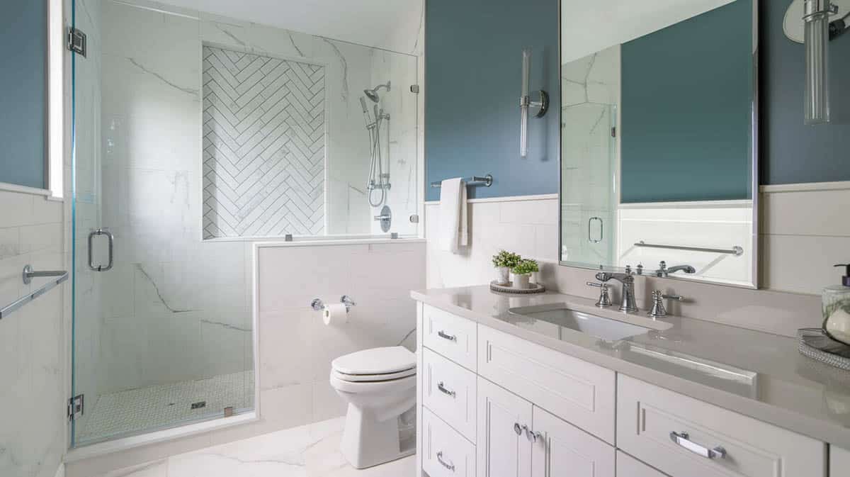 Contemporary coastal bathroom with white marble look porcelain tile and steel blue paint