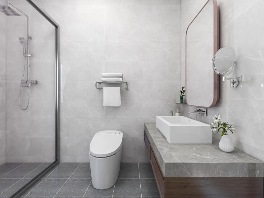 Grey modern bathroom with tile floor and wall washstand, incinerating toilet, and a shower