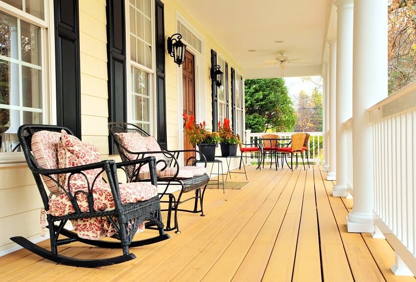 Low angle view of a porch with wall lights, rockers and red lounge chairs