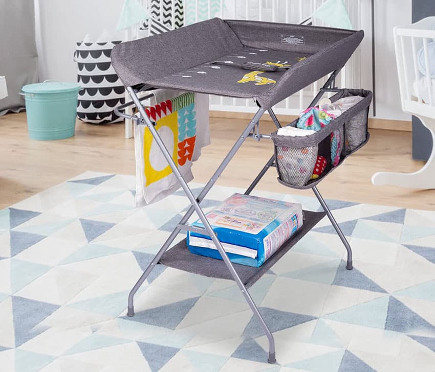 Nursery with folding table for diaper changes, rug, and wood flooring